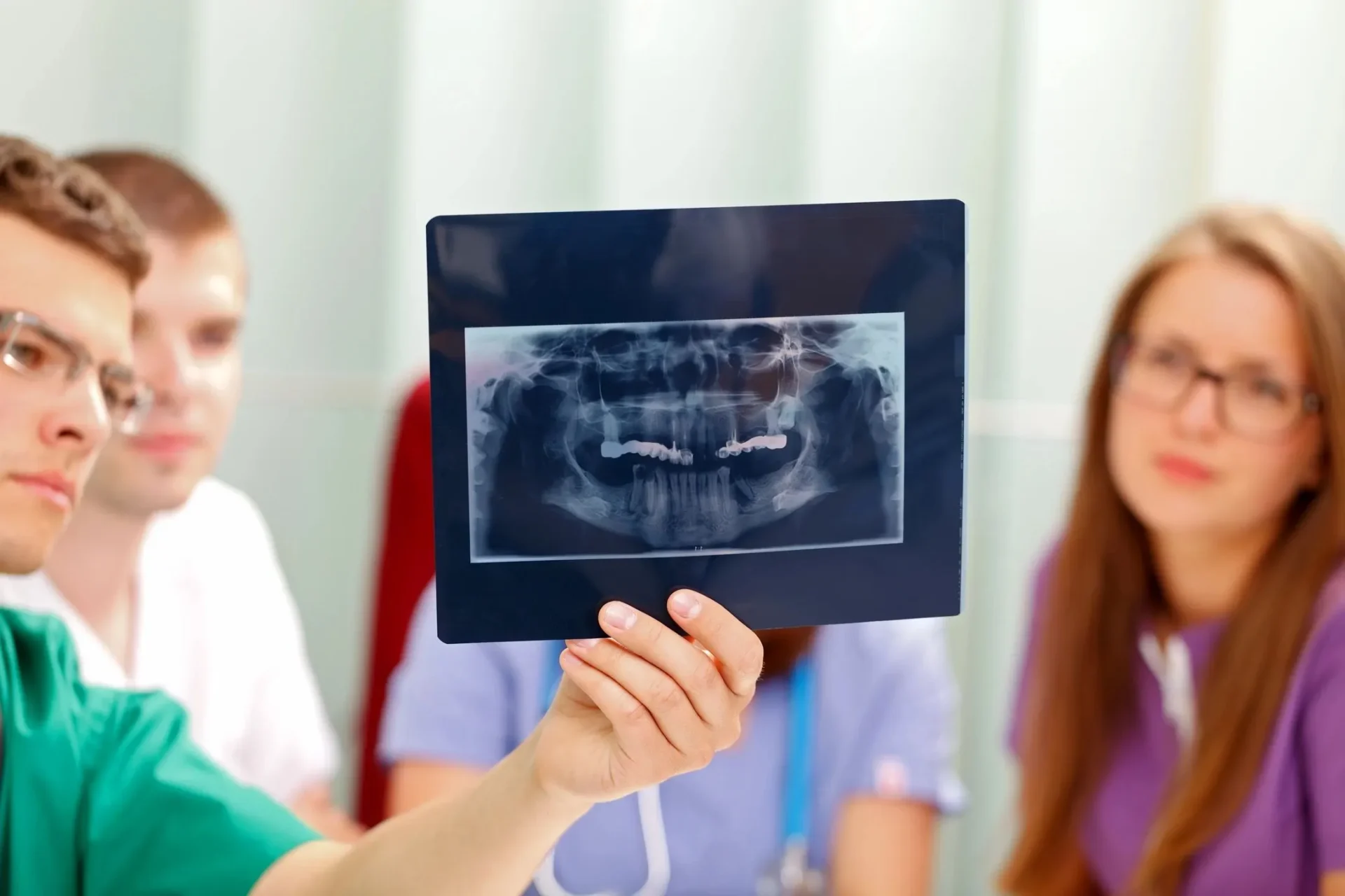 A person holding up an x-ray picture of teeth.